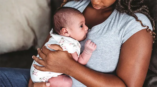 New mom holds her newborn on her chest.