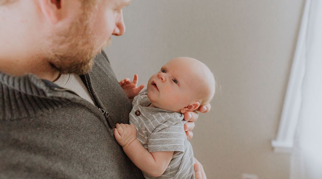 dad holds his newborn baby