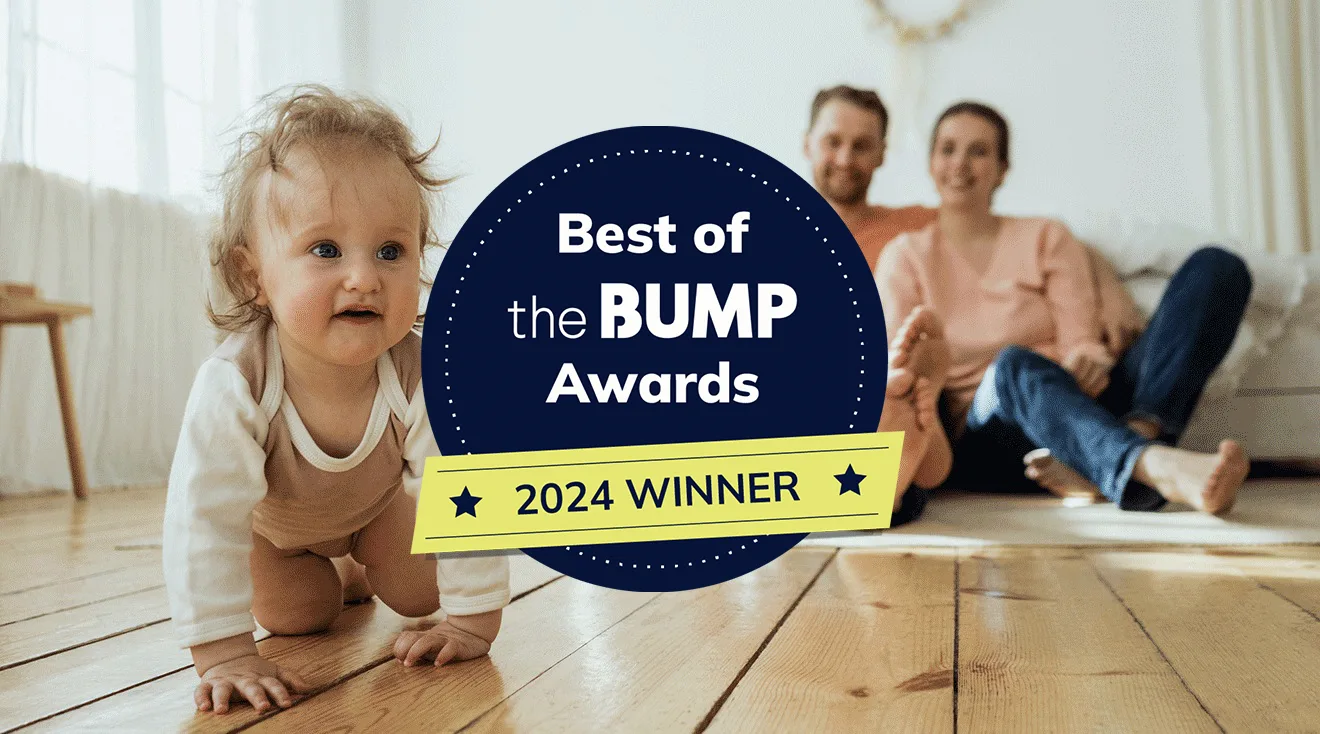 baby girl crawling at home with parents in background