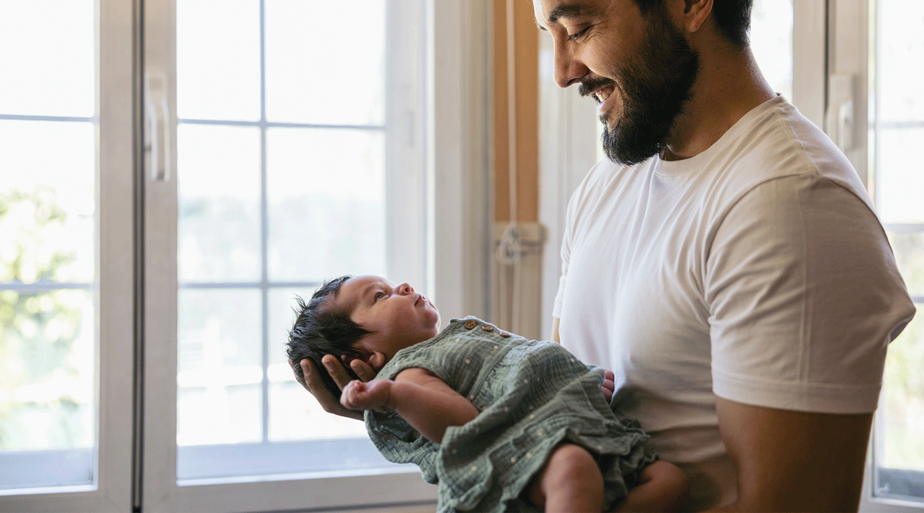 father holding newborn baby at home