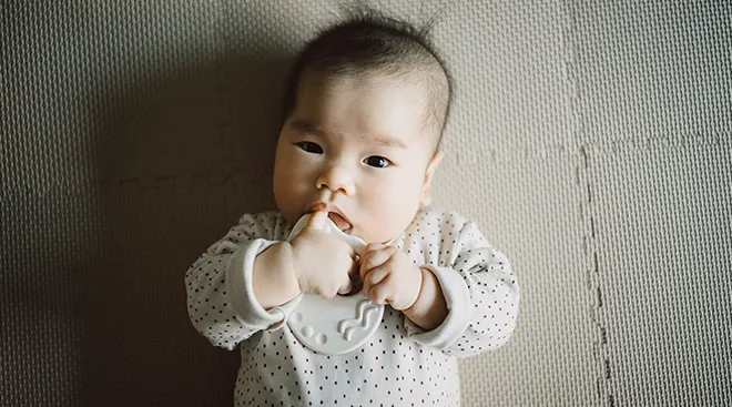 baby holding a teething toy