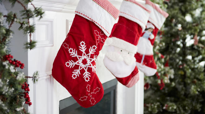 red christmas stockings hang over fireplace