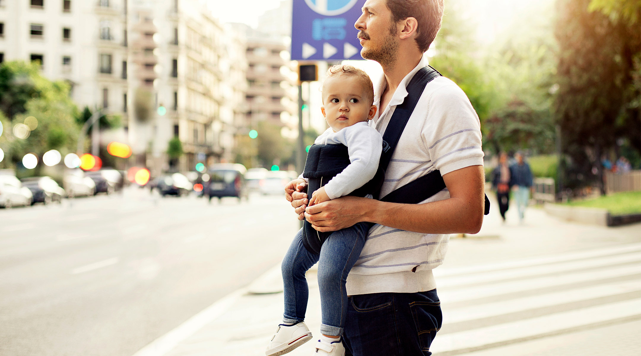 man carrying his baby via baby carrier in public