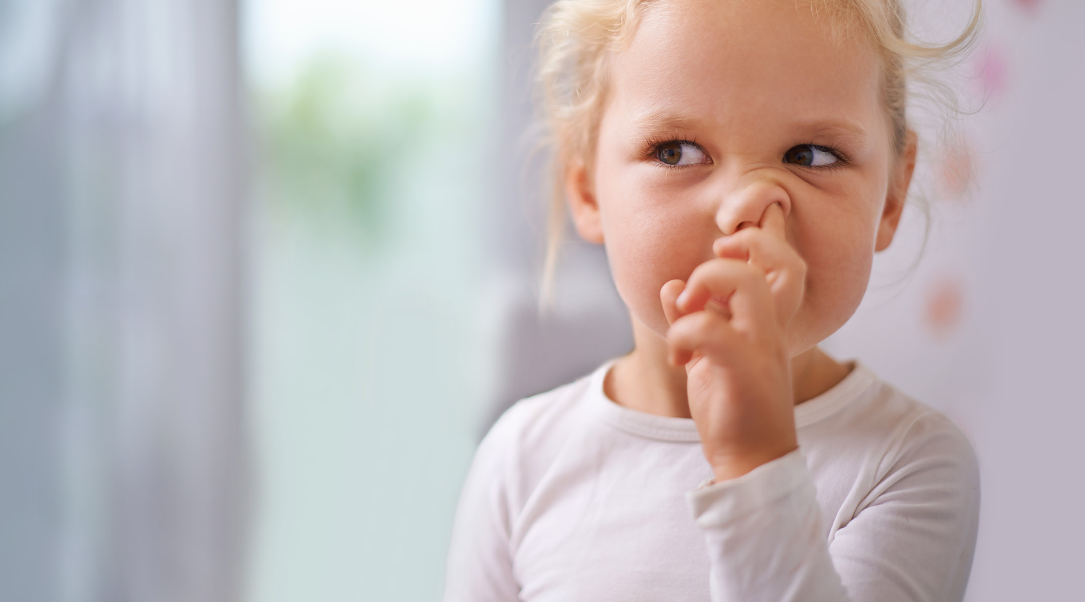 Young blonde girl picking her nose