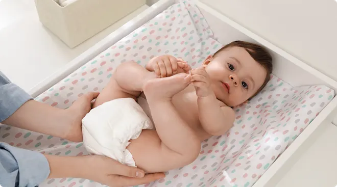 mom and dad changing baby's diaper at home