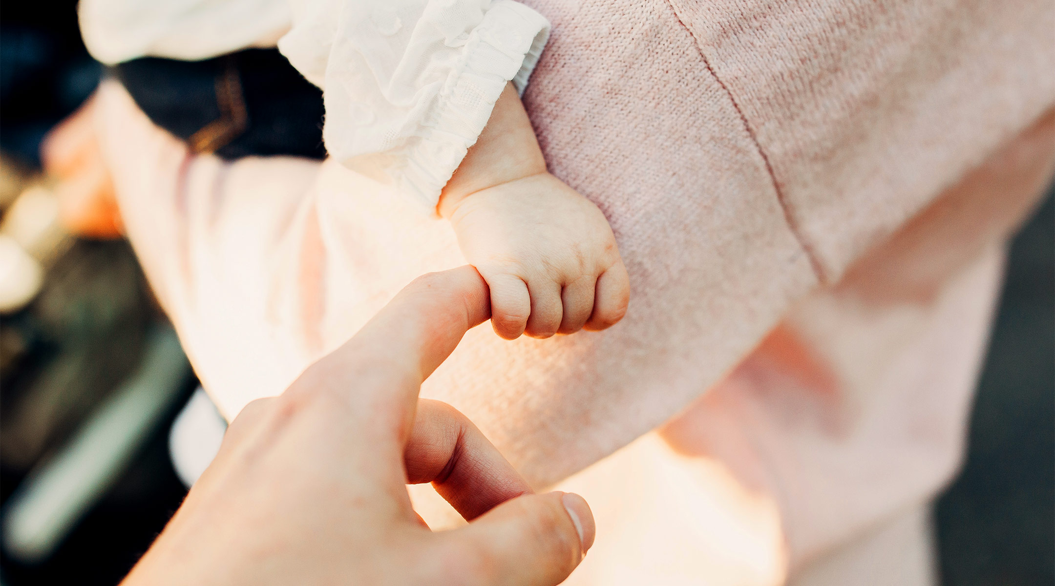 adult hand holding a baby hand