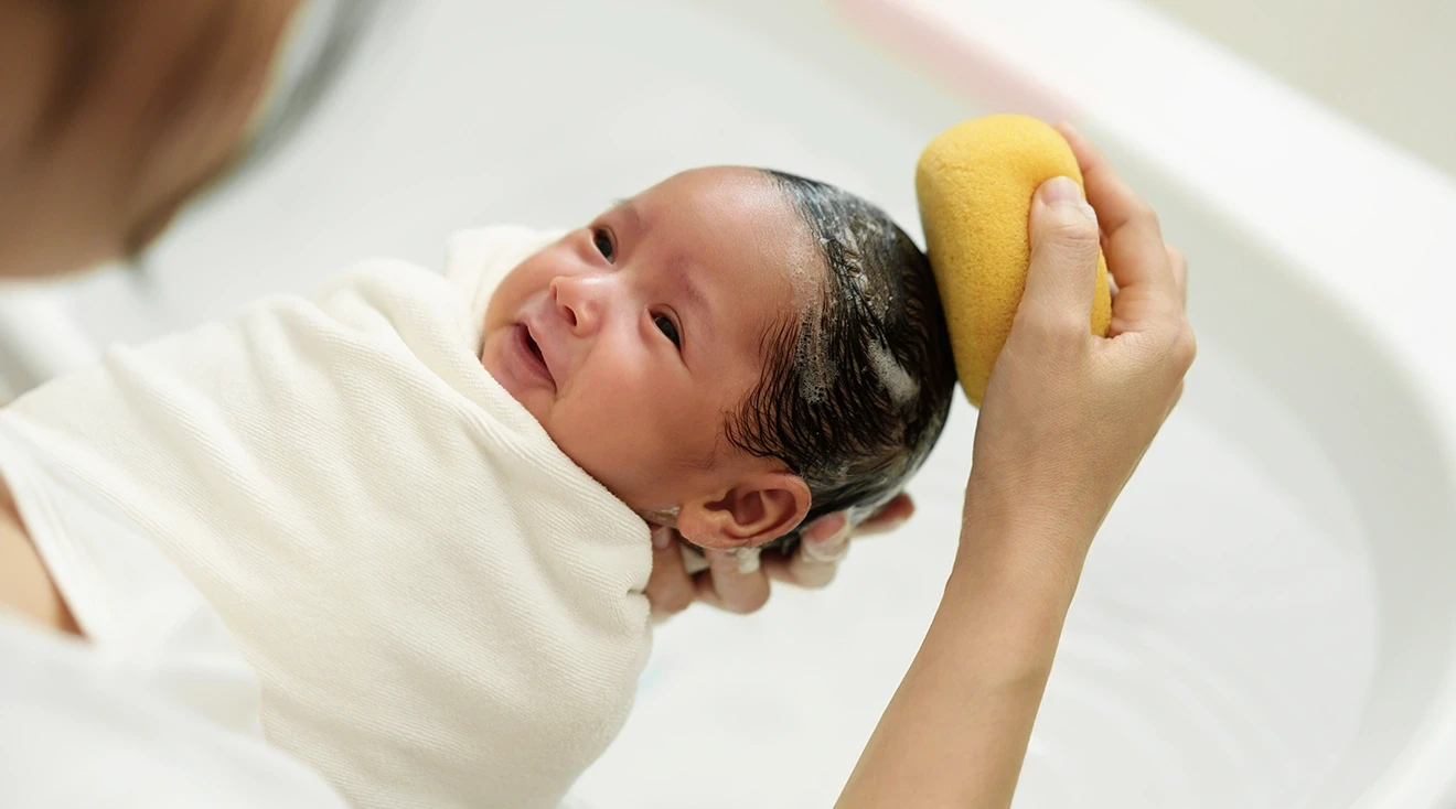 mother giving newborn baby a bath