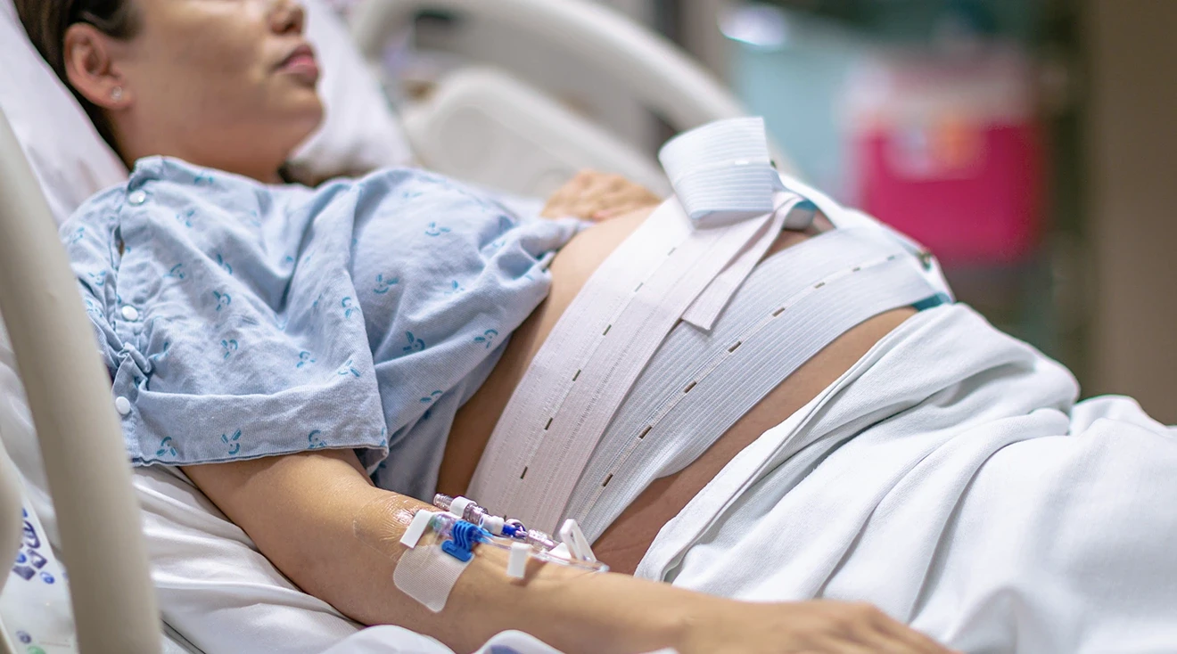 pregnant woman lying in hospital bed while in labor