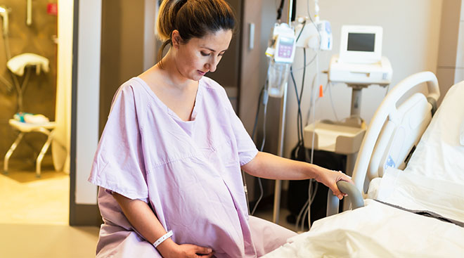 Pregnant woman sitting in hospital during labor. 