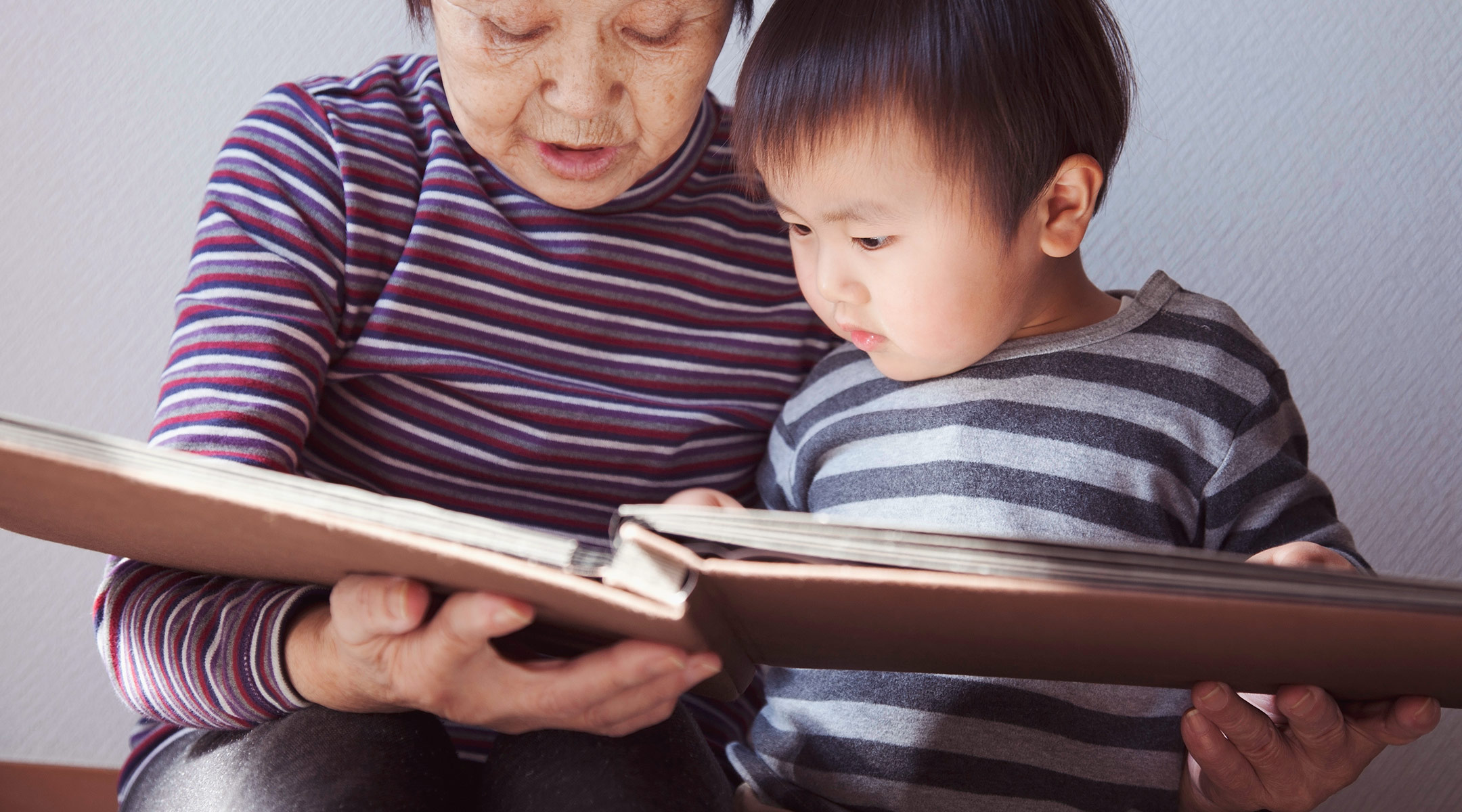 grandma and grandson look through keepsake photo album