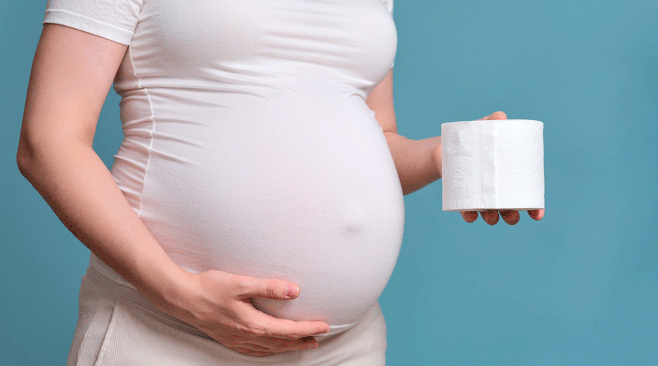 pregnant woman holding a roll of toilet paper