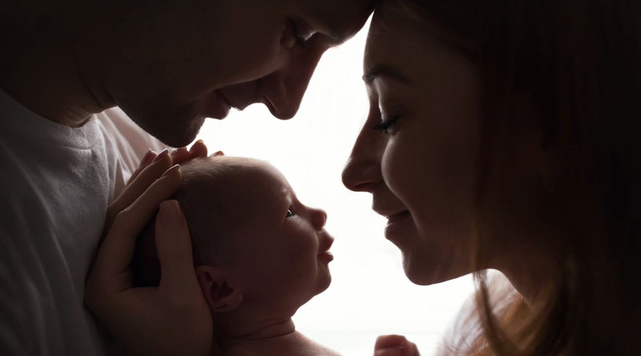 new parents holding newborn baby at home