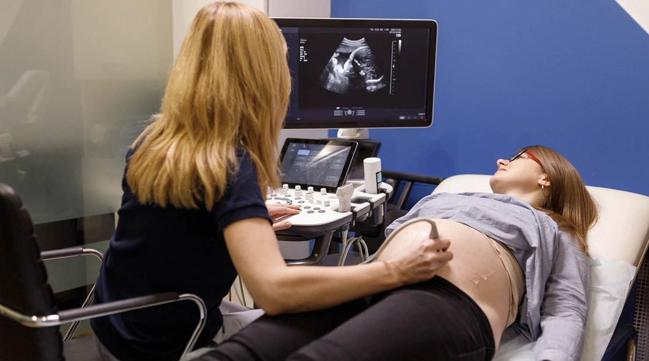 gynecologist performing an ultrasound on pregnant woman