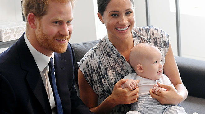 Meghan Markle and Prince Harry sitting with baby Archie. 