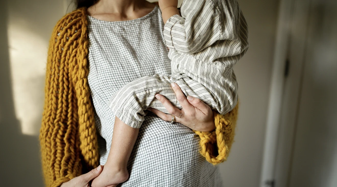 close up of pregnant woman holding a toddler in her arms