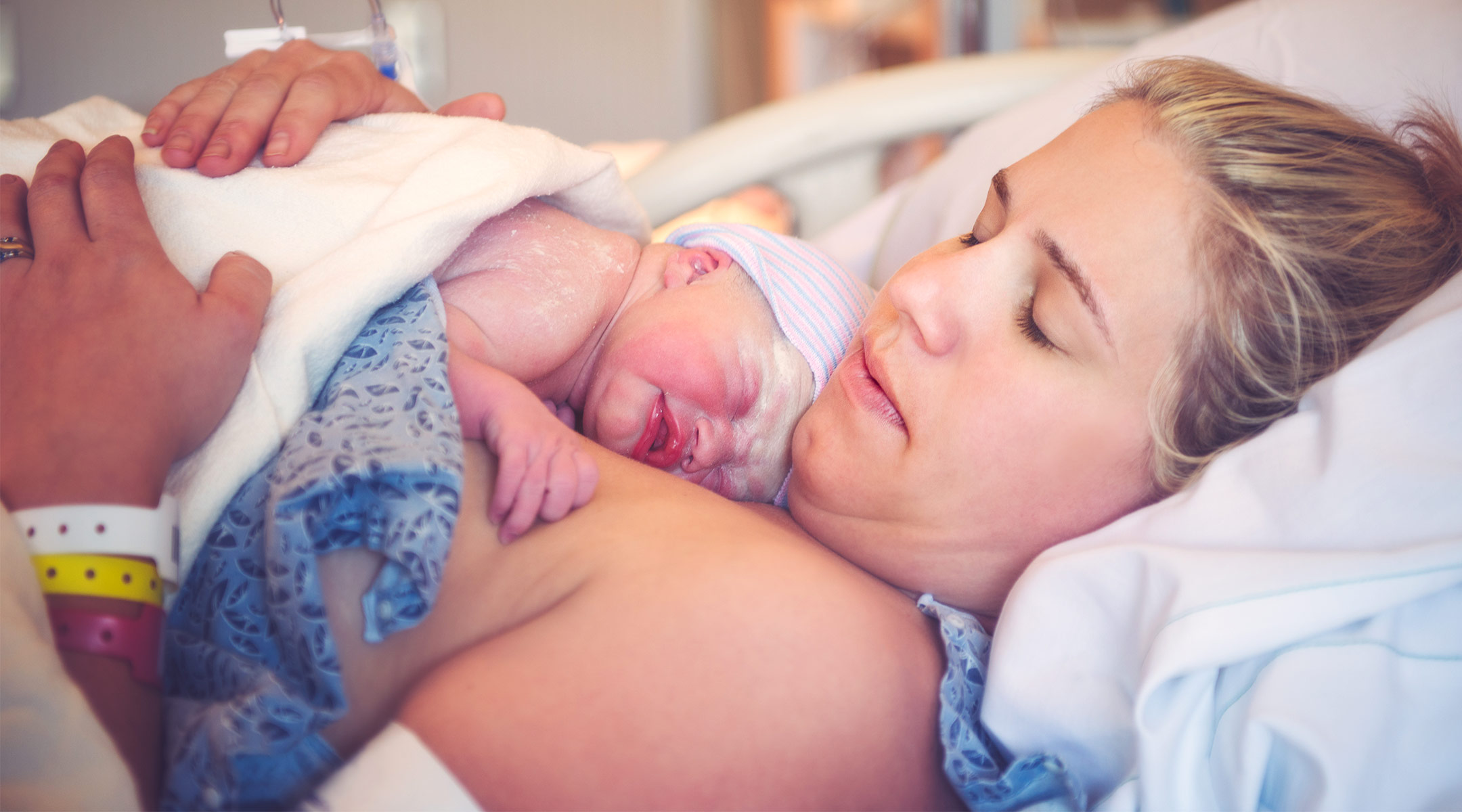 Newborn baby on new mom's chest right after birth