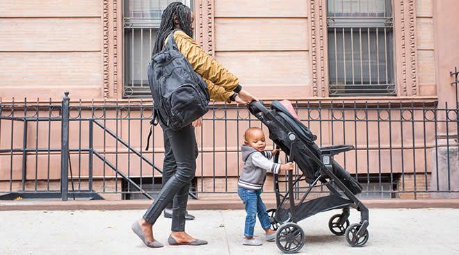 mother walking with her son and stroller on the street in neighborhood