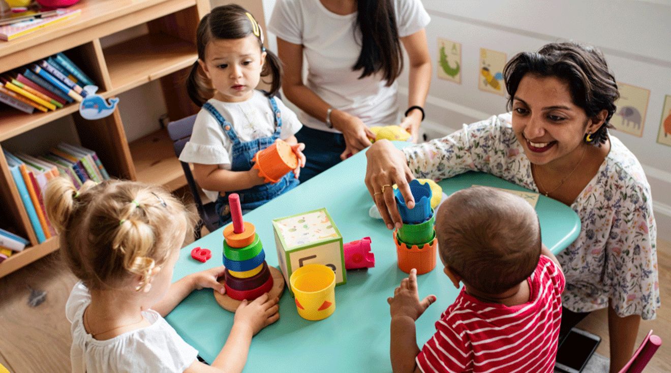 daycare teachers playing with toddlers at table