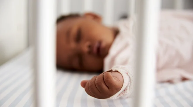 close up of baby sleeping in crib