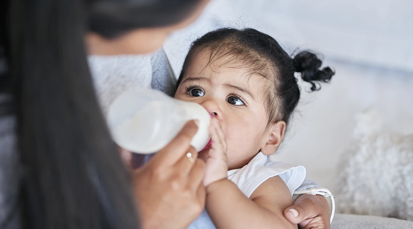 mother feeing bottle to baby