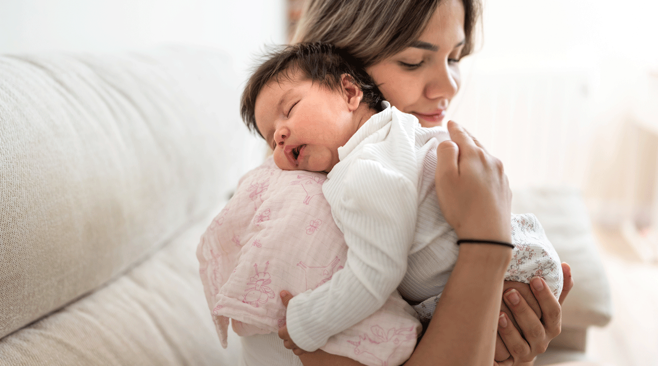 mom holding sleeping baby