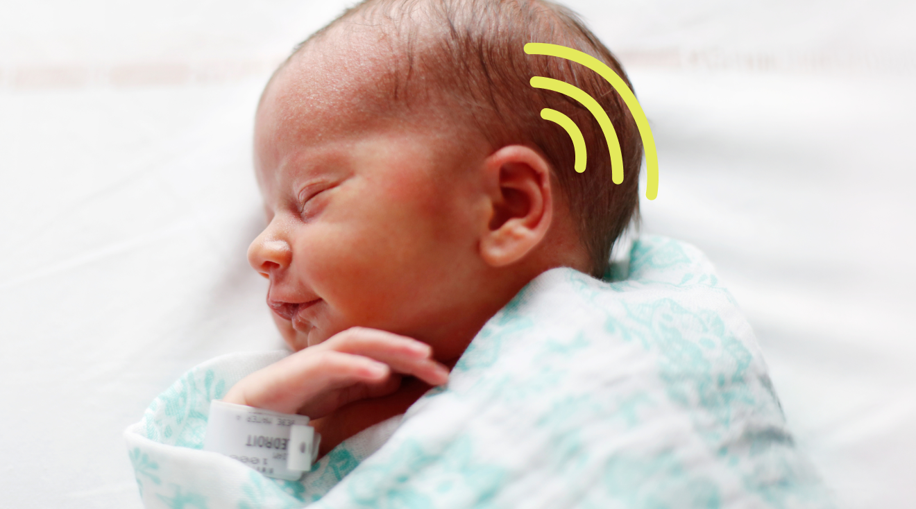 newborn baby swaddled with hearing graphic around ear