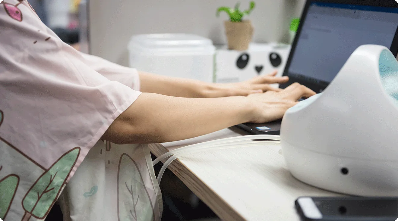 woman breast pumping at desk at work