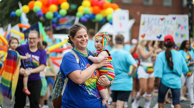 mom holding baby at gay pride parade event