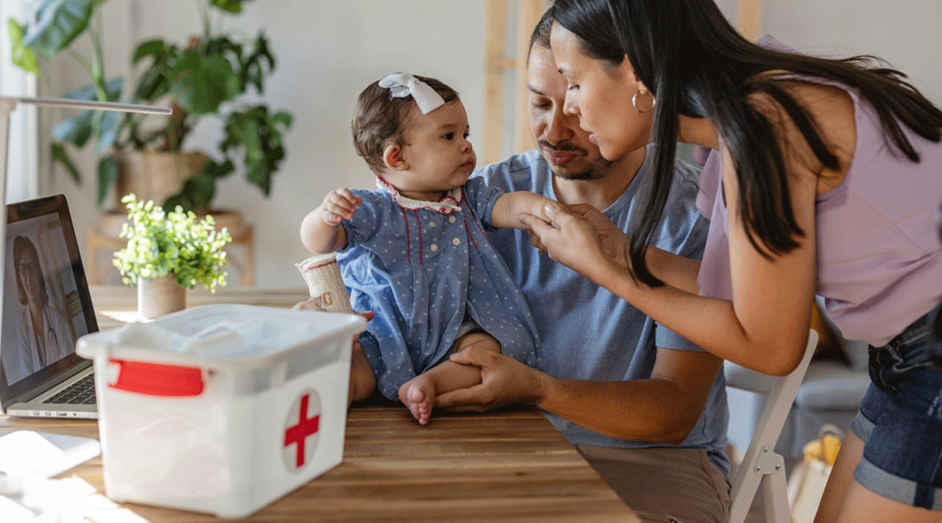 parents helping baby with first aid kit