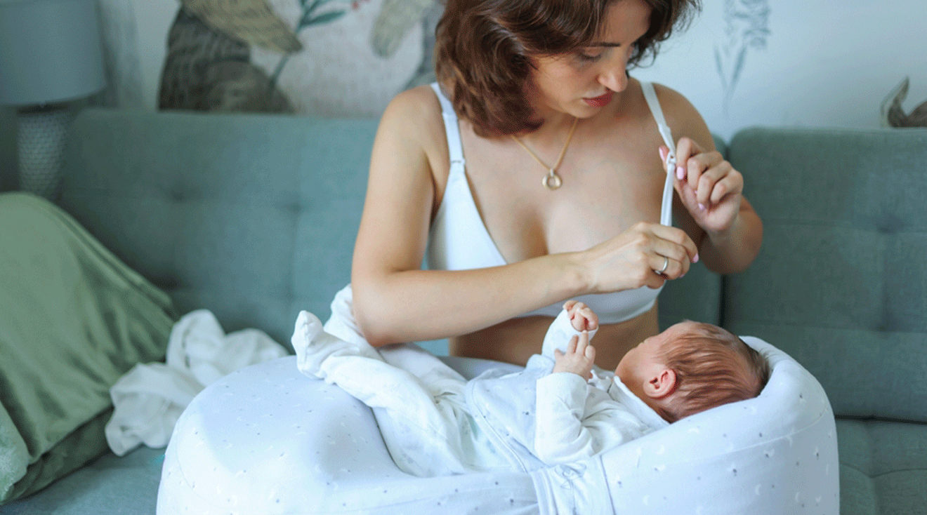 mother getting ready to breastfeed newborn baby at home