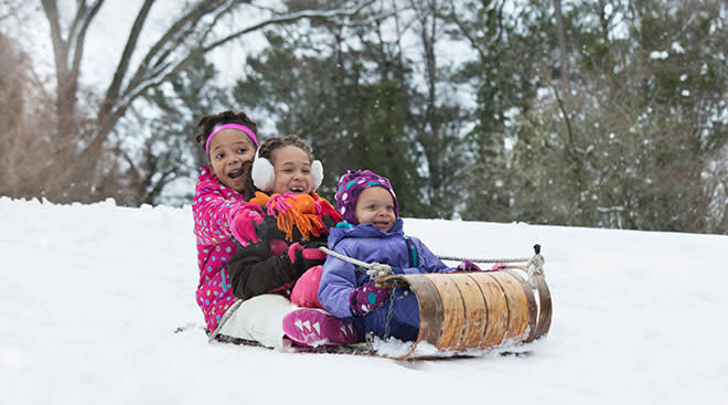 African-American kids on a sled in the snow