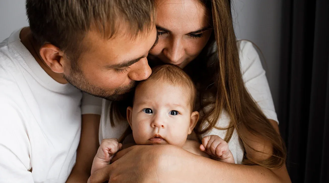 parents kissing baby