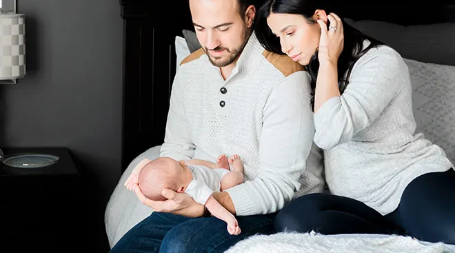 new parents embracing their newborn baby at home