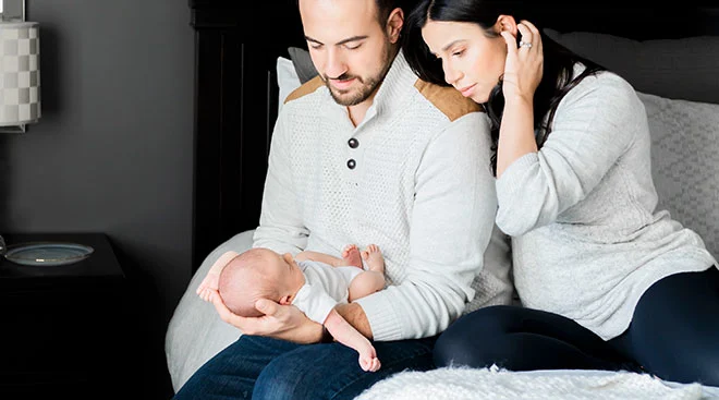 new parents embracing their newborn baby at home