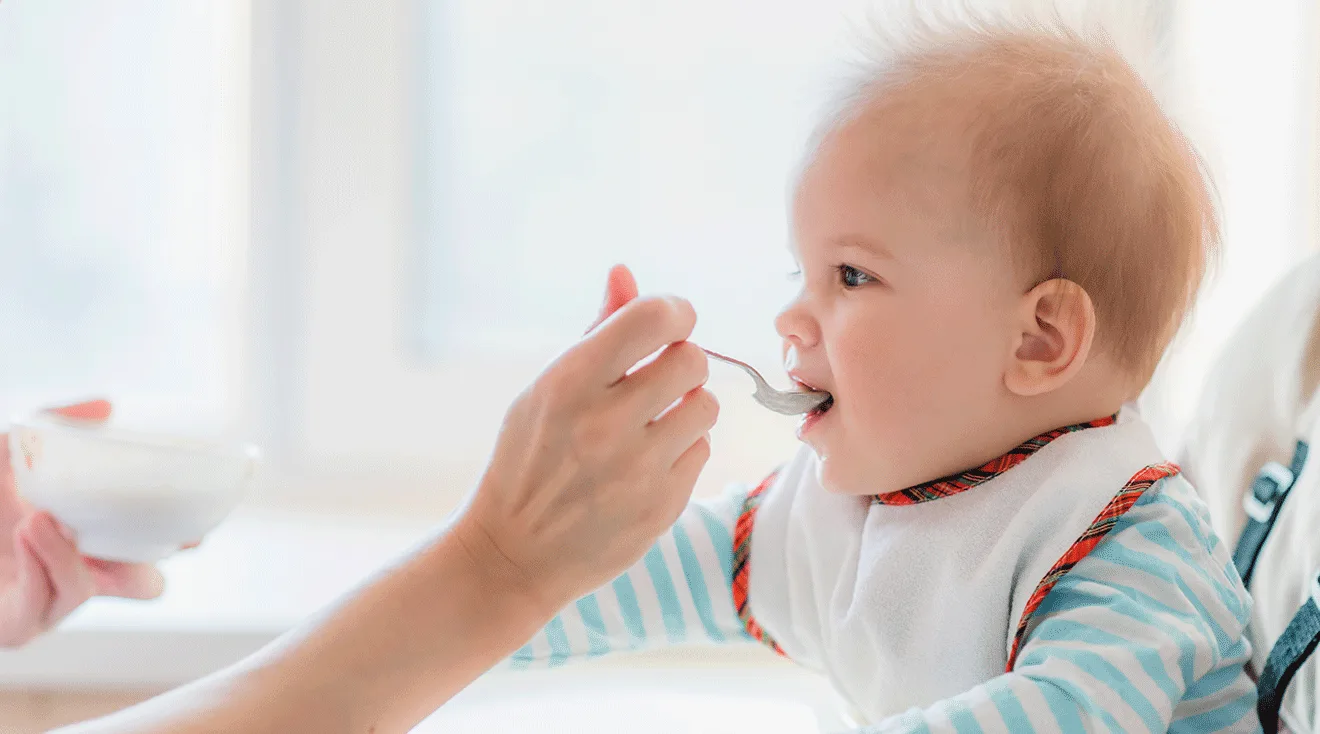 mother feeding baby in high chair