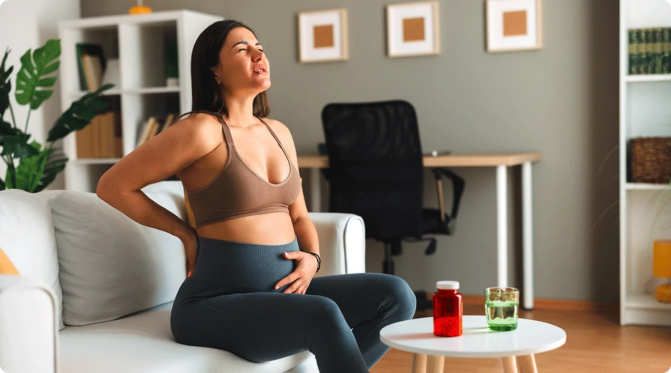 pregnant woman with tail bone pain at home on the couch