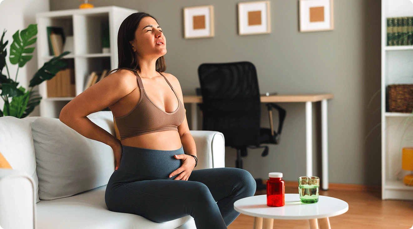 pregnant woman with tail bone pain at home on the couch