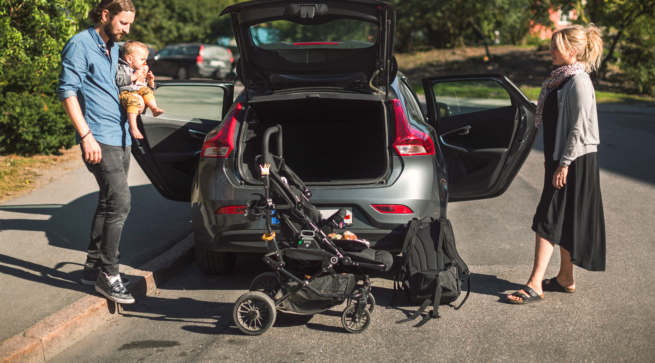 parents getting ready to put baby and stroller in their car