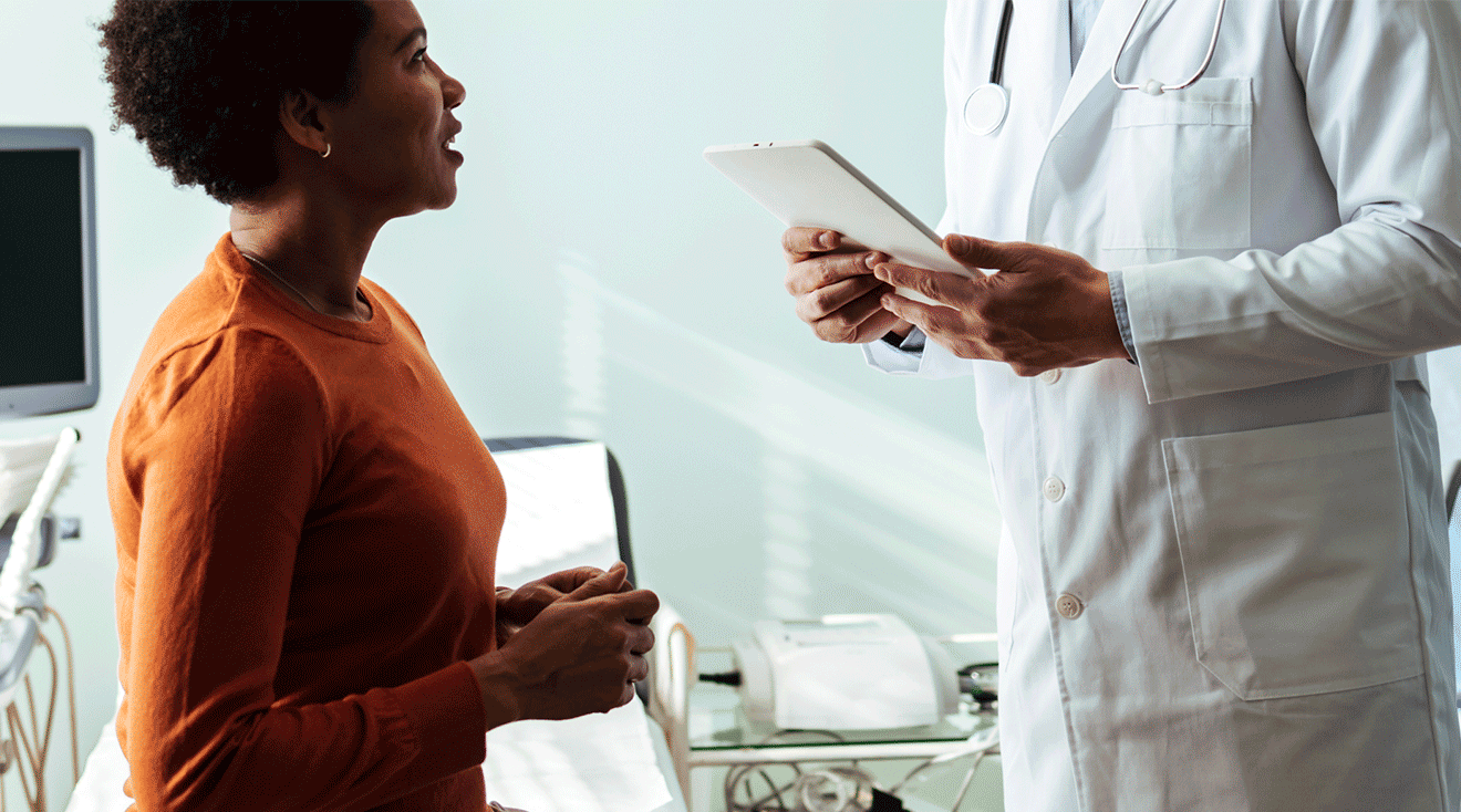 black woman talking to doctor in exam room