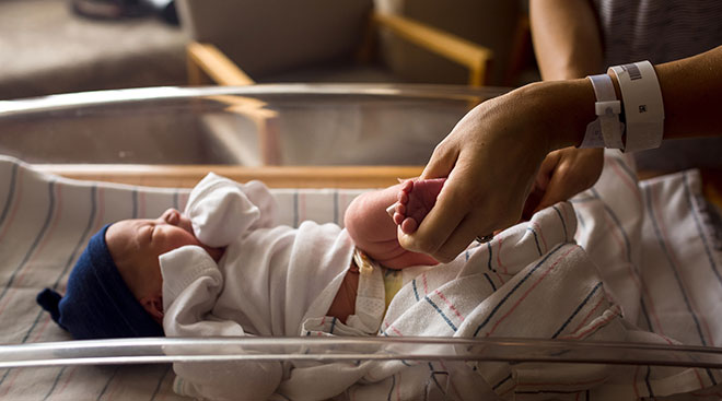 parent holds newborn in hospital after birth