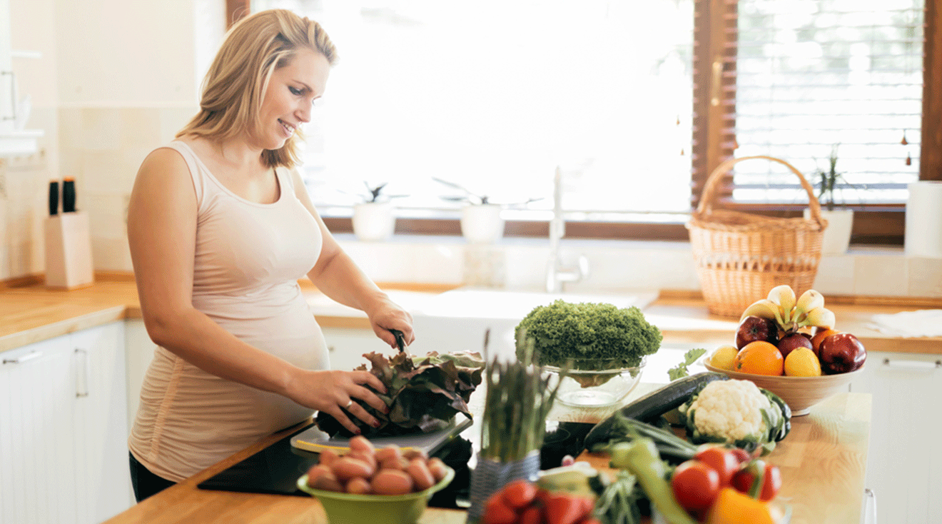 pregnant woman cooking food at home