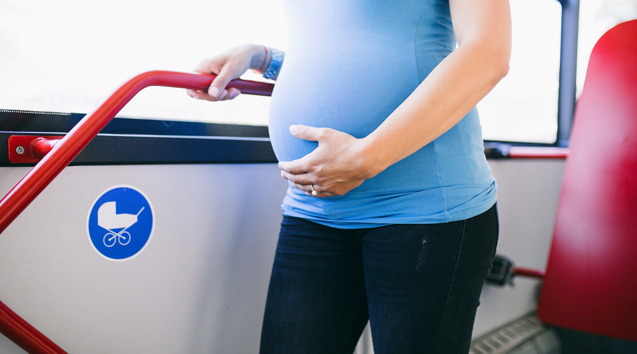 pregnant woman standing on bus