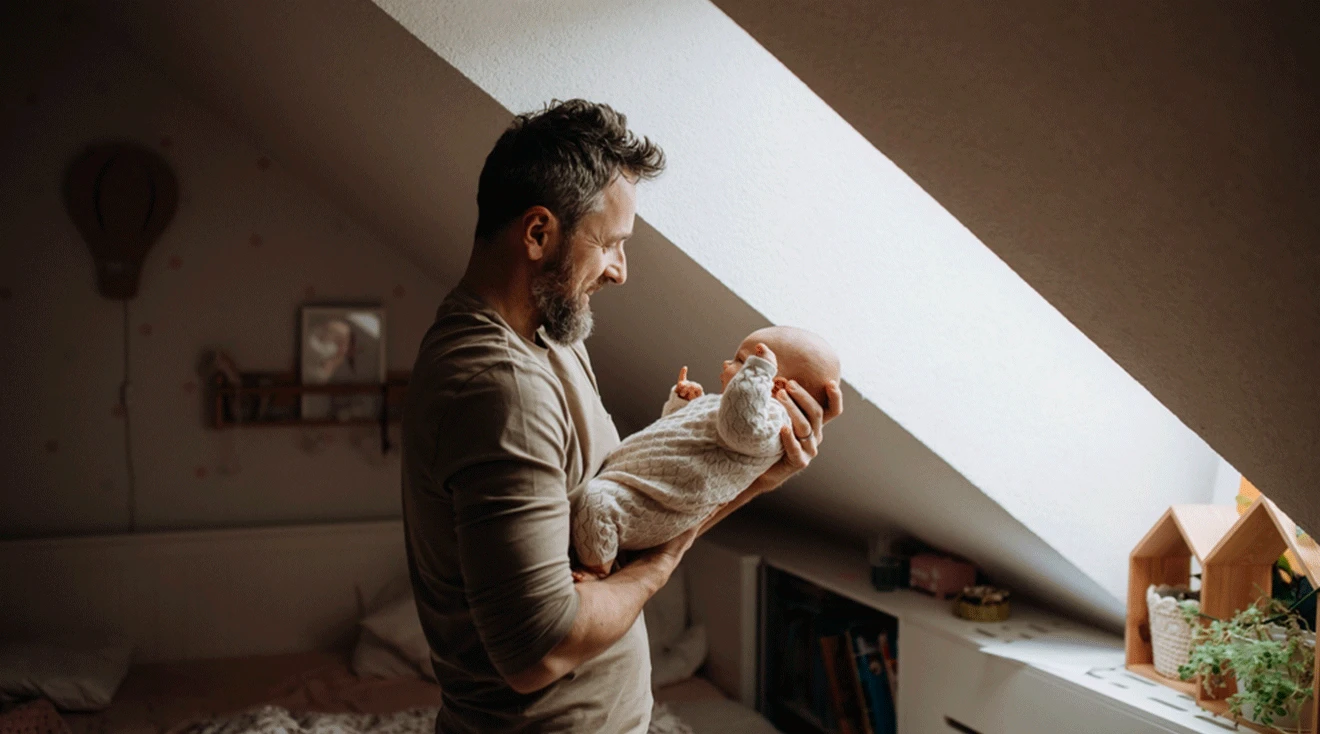father holding and looking at infant baby