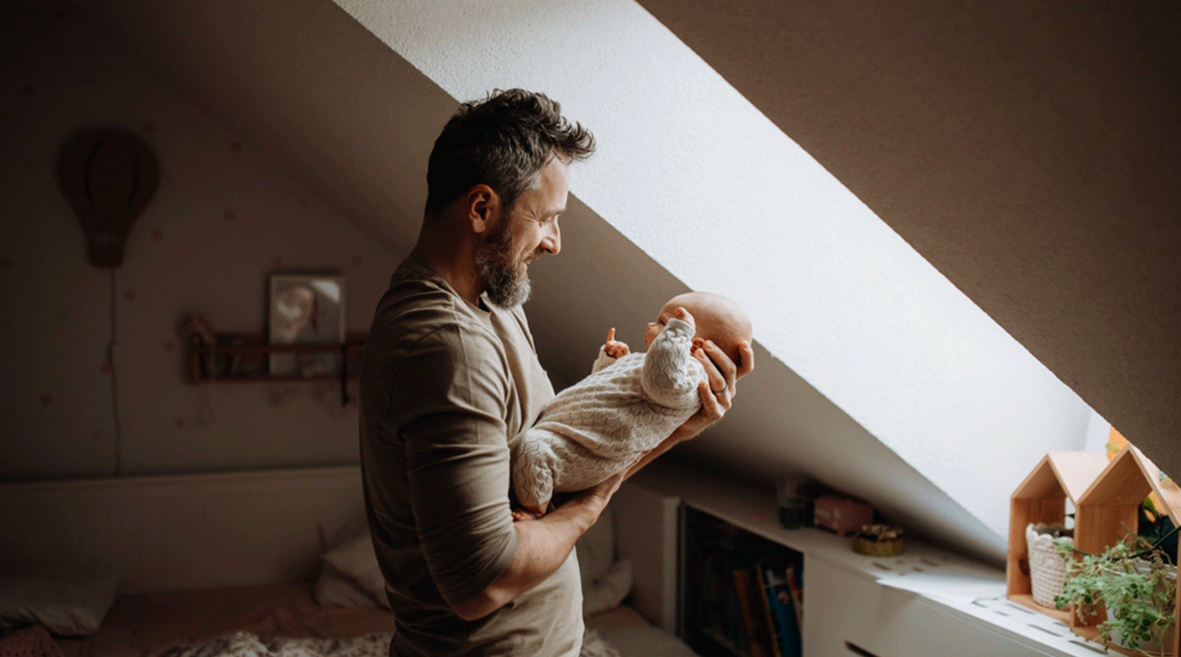 father holding and looking at infant baby