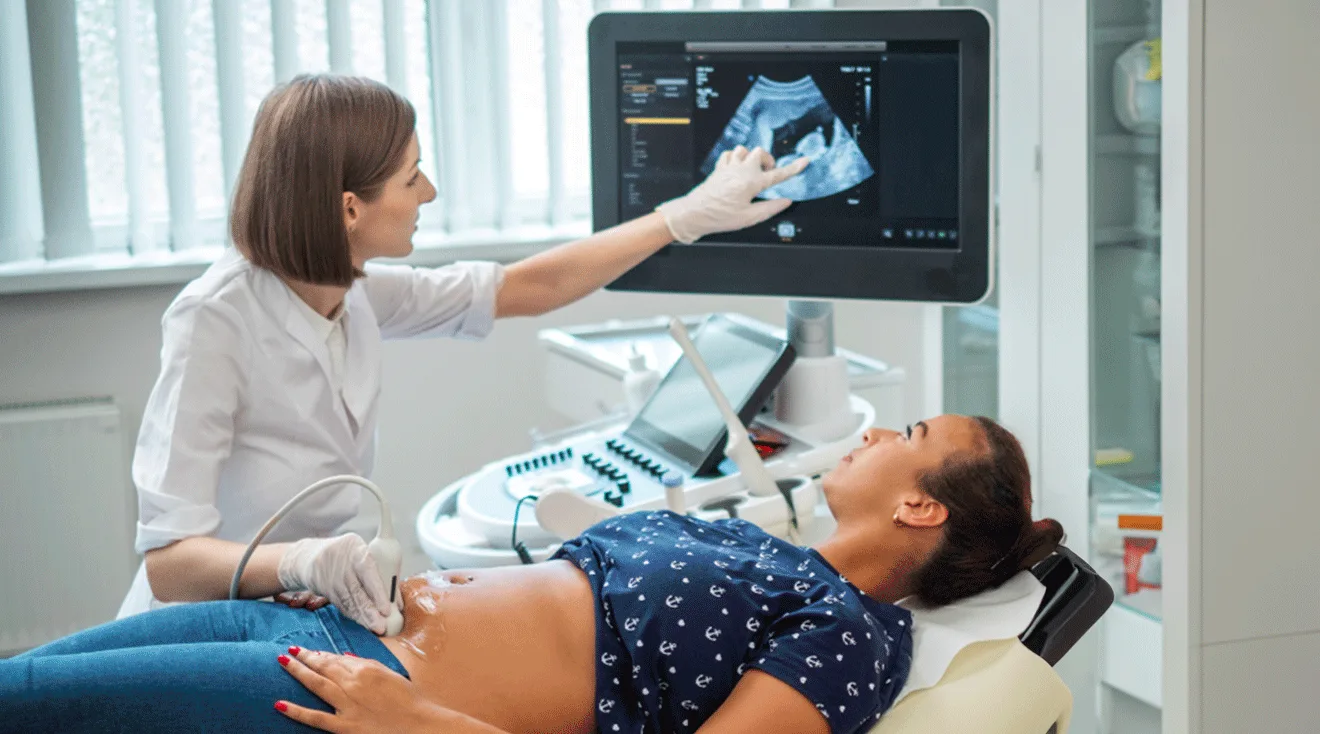 doctor performing an ultrasound on pregnant woman in first trimester