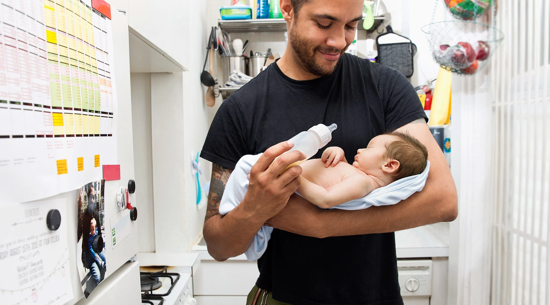 dad feeding his newborn baby