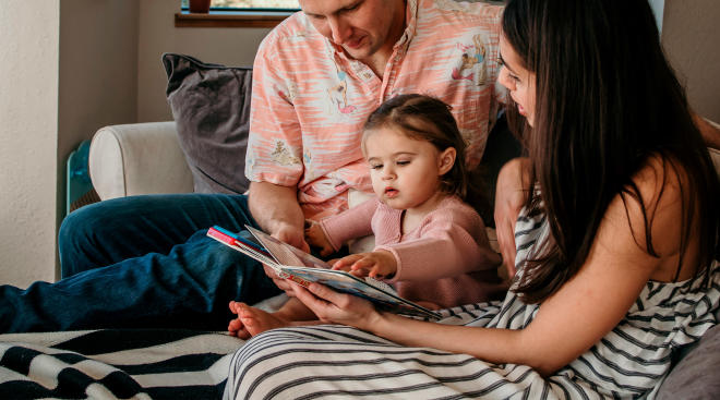 parents reading to one and a half year old daughter, who is developing her speech