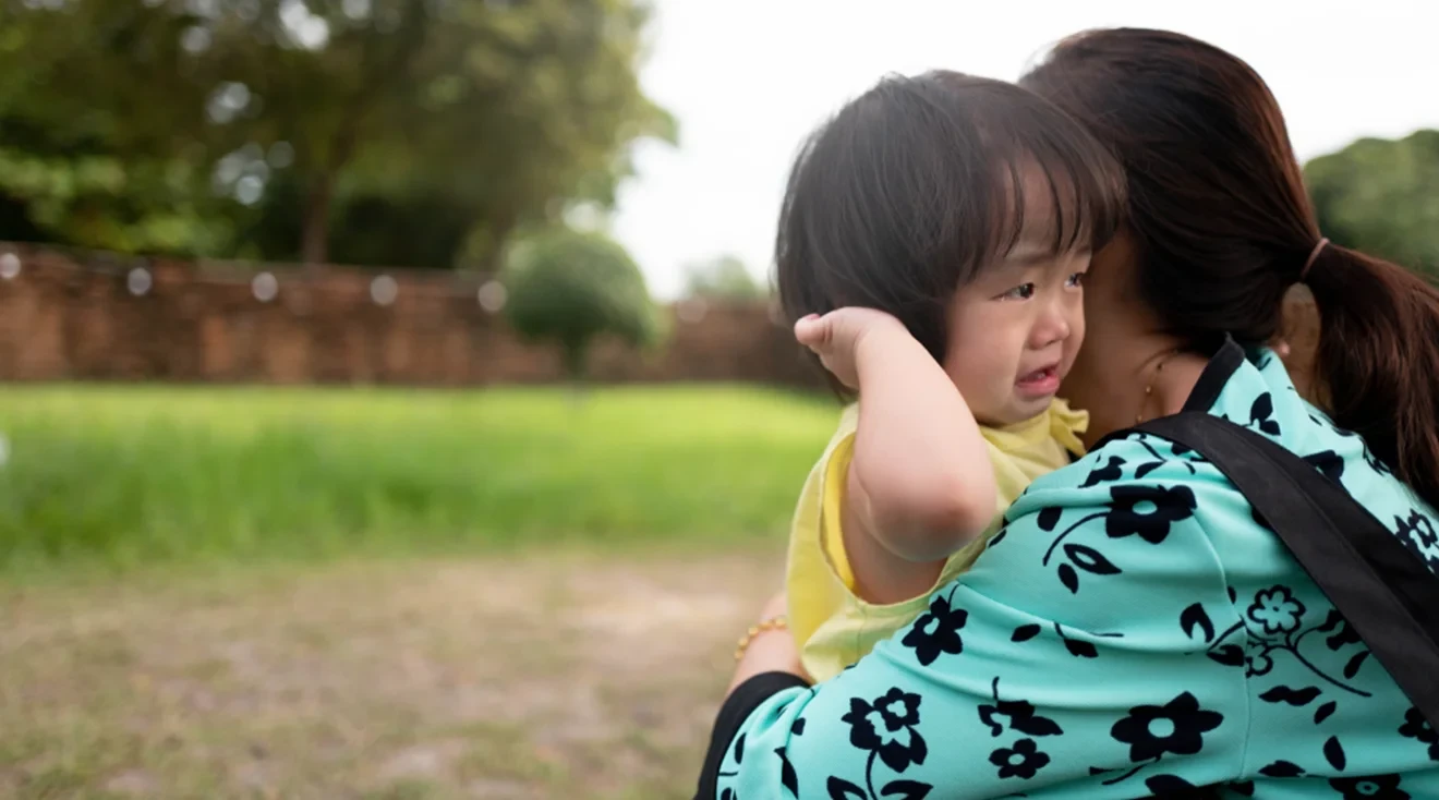 mother hugging her crying toddler