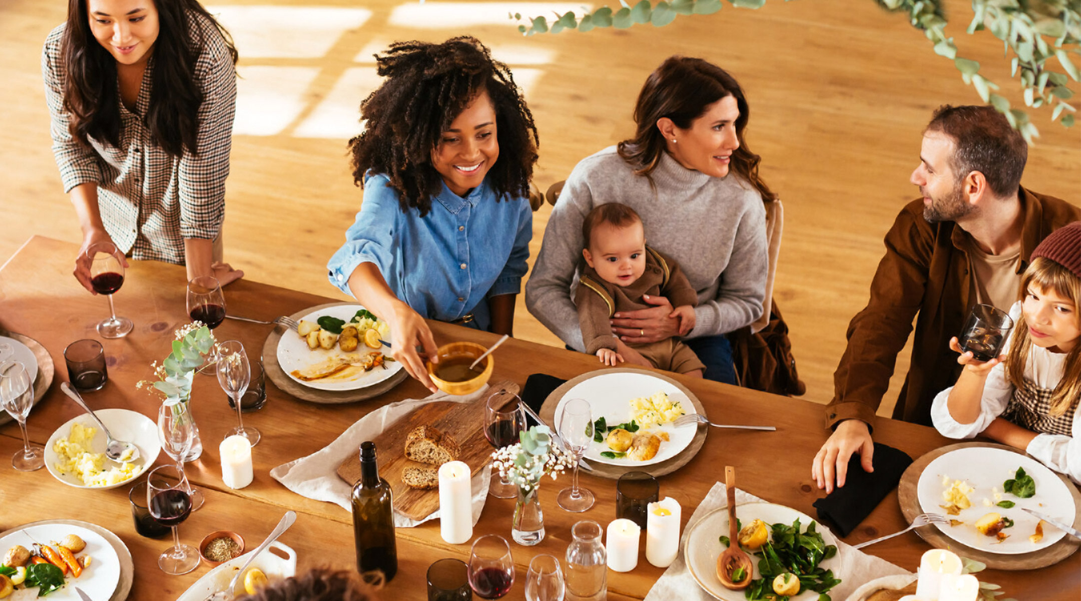 Family gathering around Thanksgiving dinner table