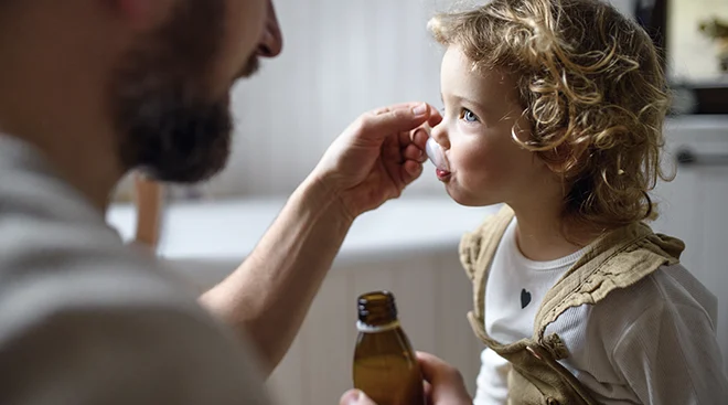 father giving daughter medicine 